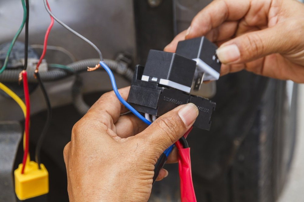 Auto electrician installing car electrical parts and relay wiring in Boonah