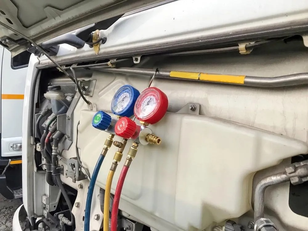 Truck air conditioning pressure gauges connected during a regas in Boonah