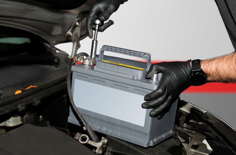 Mechanic fitting a new car battery into a diesel vehicle in Boonah