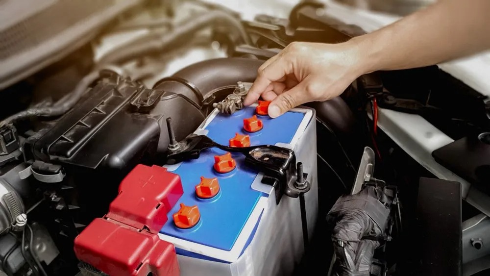 Mechanic checking a car battery under the bonnet in Boonah