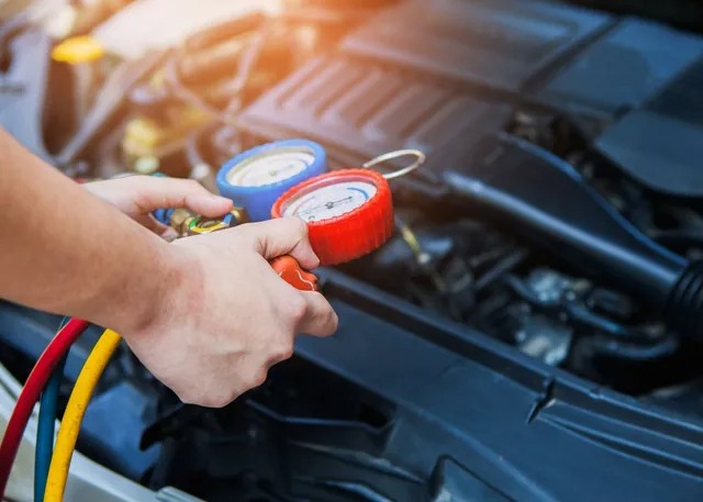 Mechanic checking a car air conditioning system with manifold gauges in Boonah